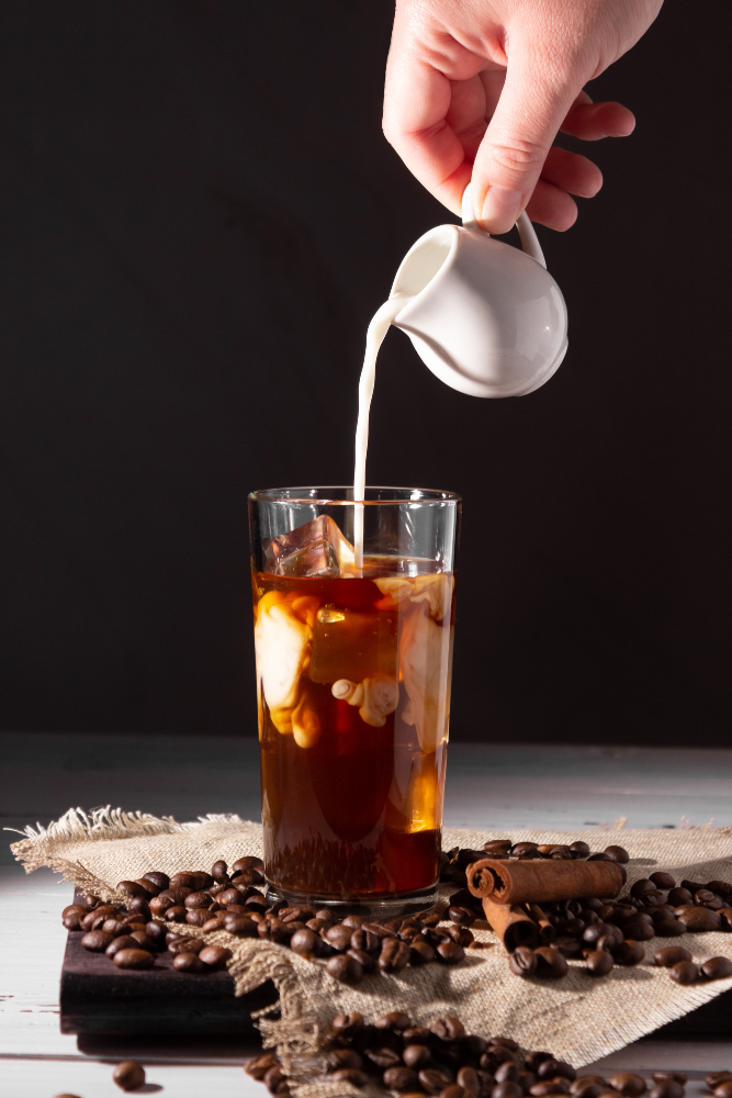 glass cup with cold coffee ice coffee beans dark background