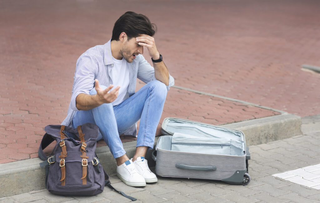 sad man sitting international airport with luggage 1 54